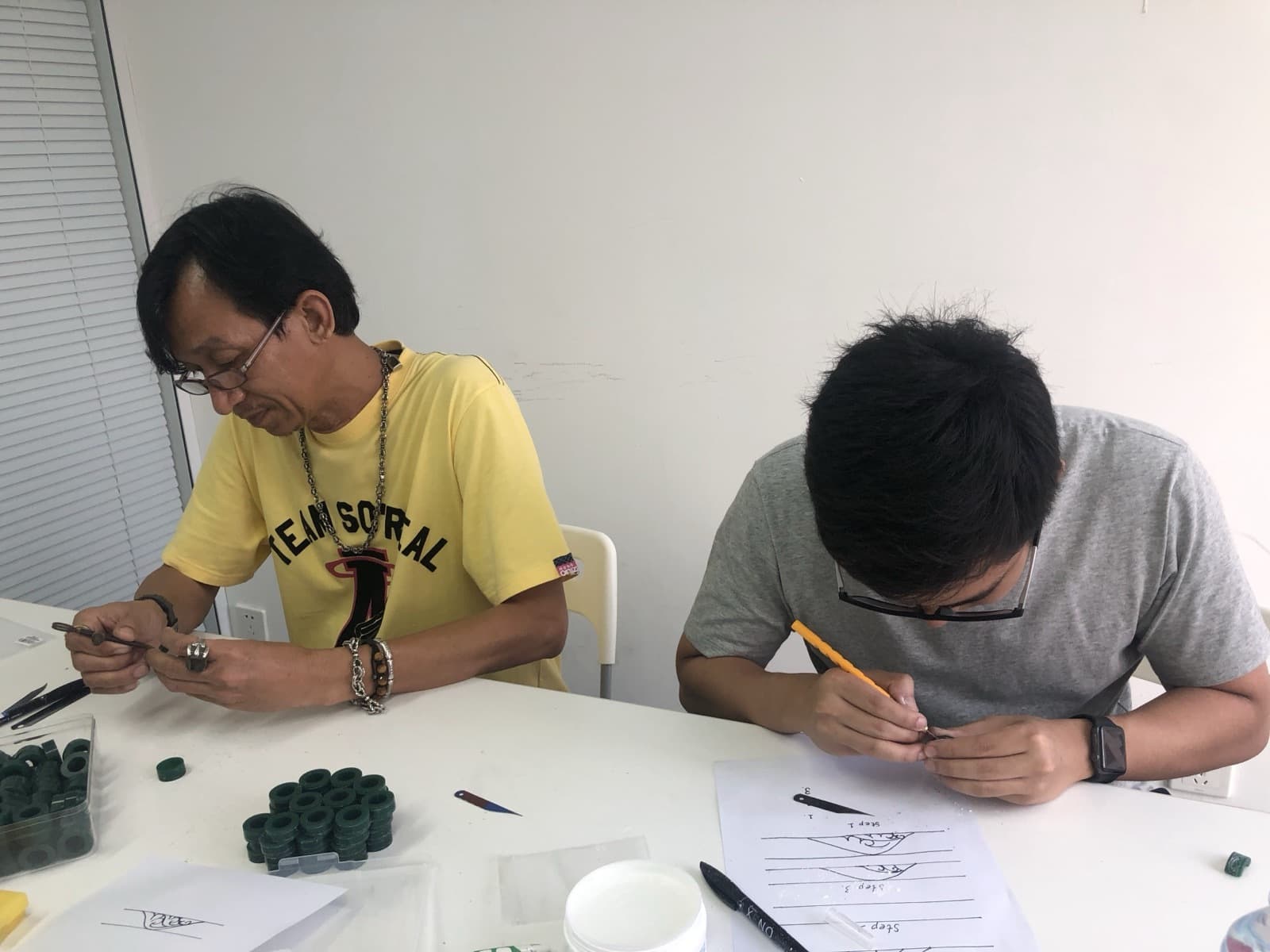 Craftsmen hand-carving wax masters.